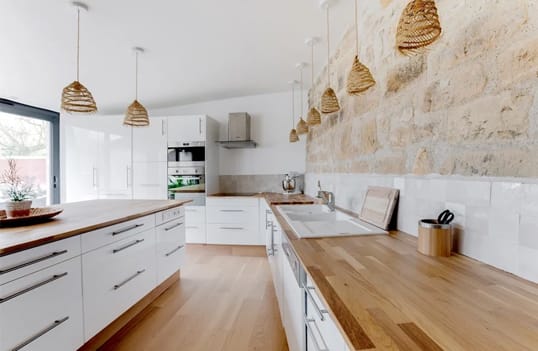 Cuisine ouverte style campagne chic avec plan de travail et ilot central en bois massif
